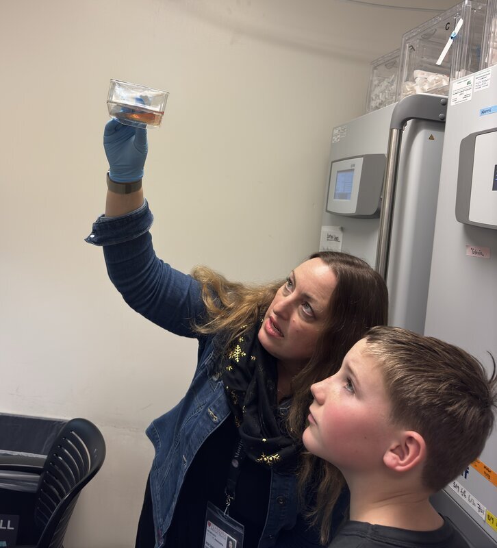 Dr. Michelle Monje showing a mouse brain to Max Weekly during a lab visit